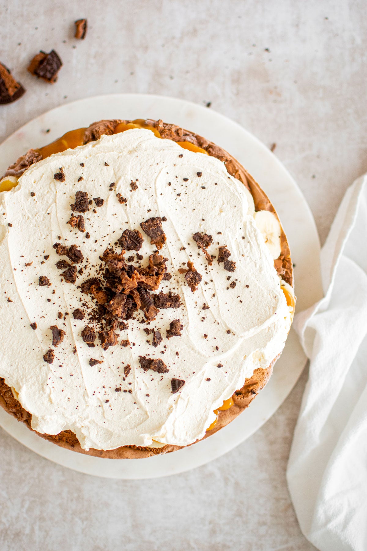 chocolate banana caramel ice cream pie on a white marble serving board.