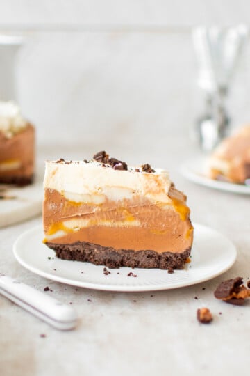 chocolate banana caramel ice cream pie slice on a plate on a table.