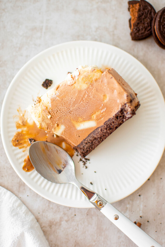 chocolate banana caramel ice cream pie slice on a plate with a spoon.