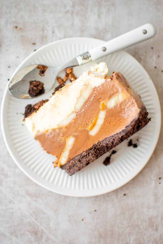 chocolate banana caramel ice cream pie slice on a plate with a spoon.