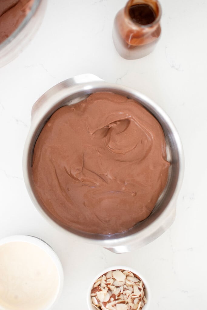 chocolate ice cream mix in a cake pan on a white marble countertop.