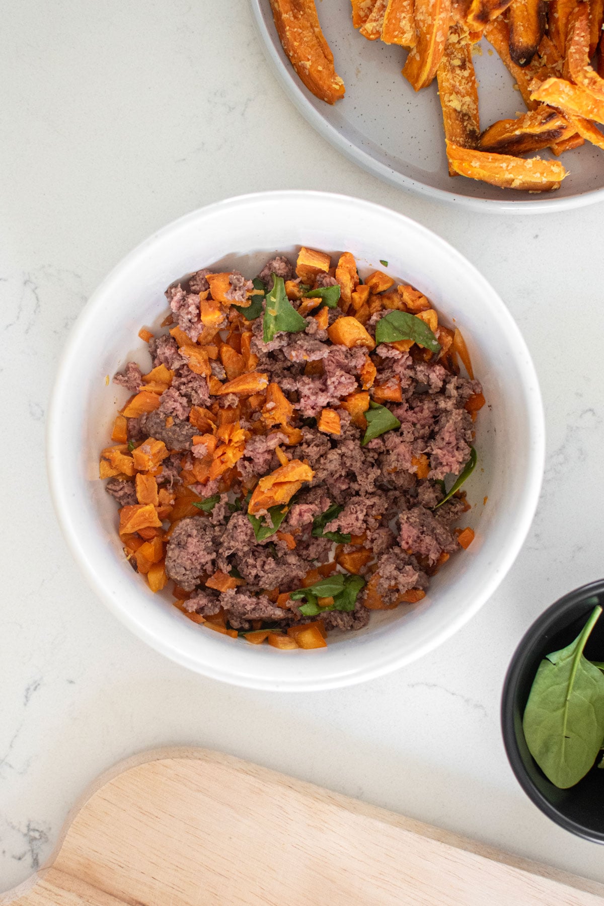 homemade beef dog food in a dog bowl on a white marble countertop.