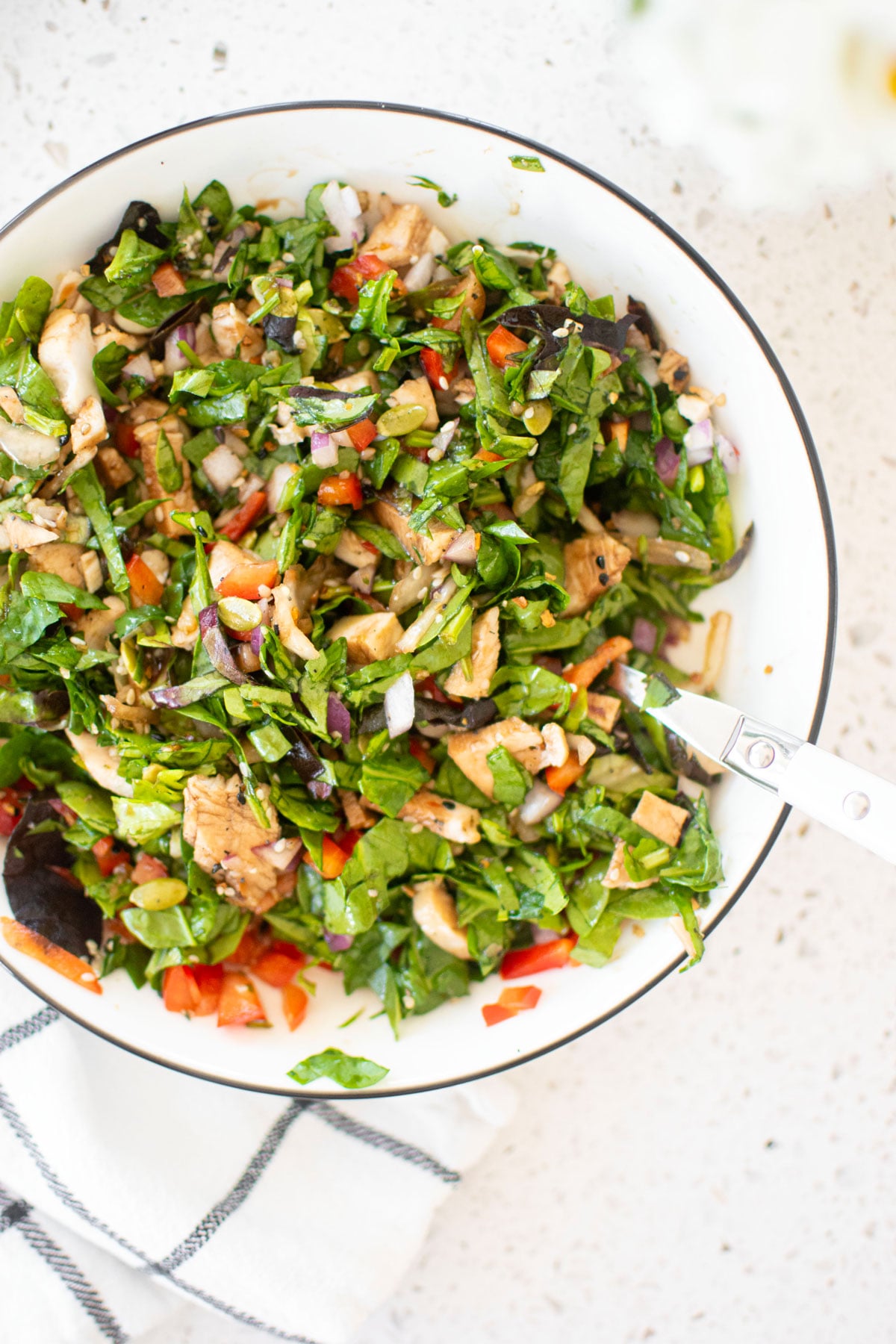gut healthy chicken salad mixed together in a large bowl on a white countertop.