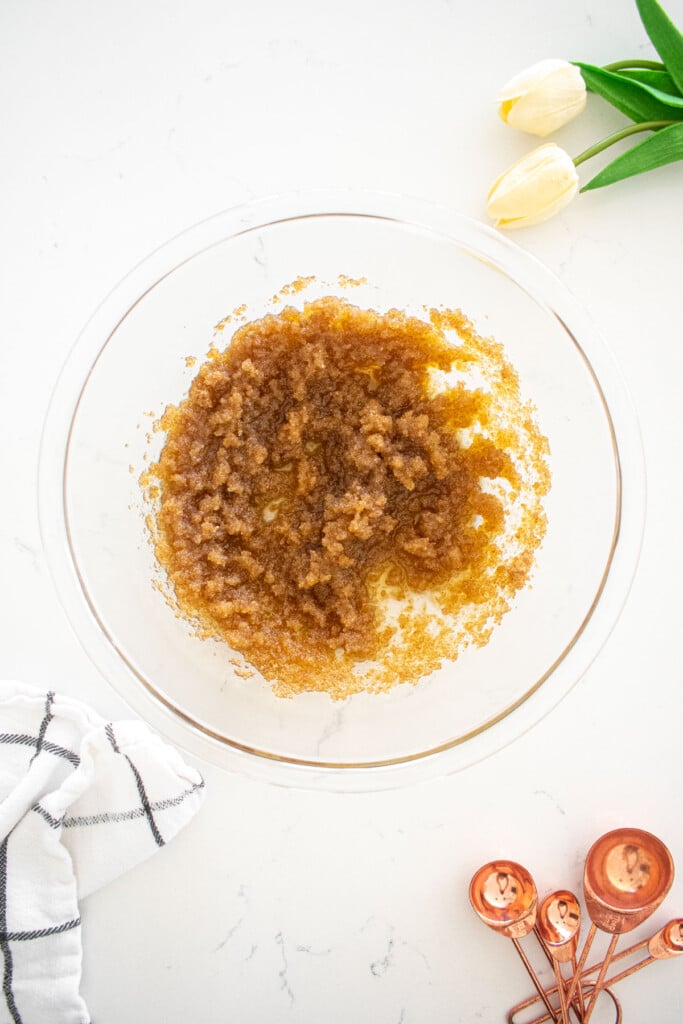 glass mixing bowl with olive oil and sugar mixed together.