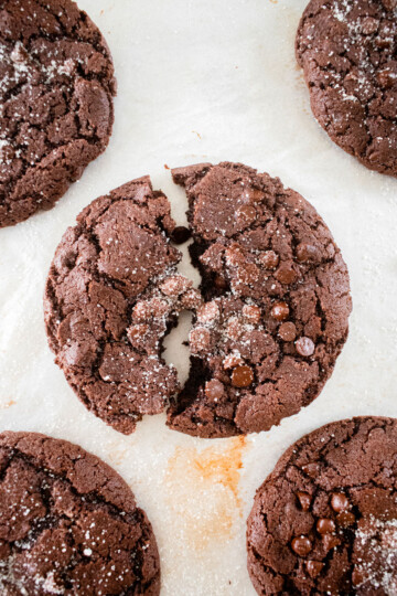 chewy chocolate espresso cookie broken in half on a baking sheet.