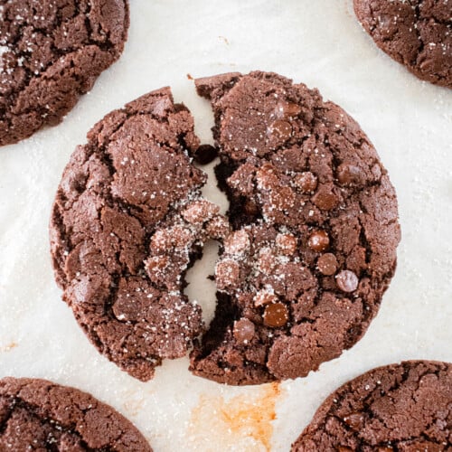 chewy chocolate espresso cookie broken in half on a baking sheet.
