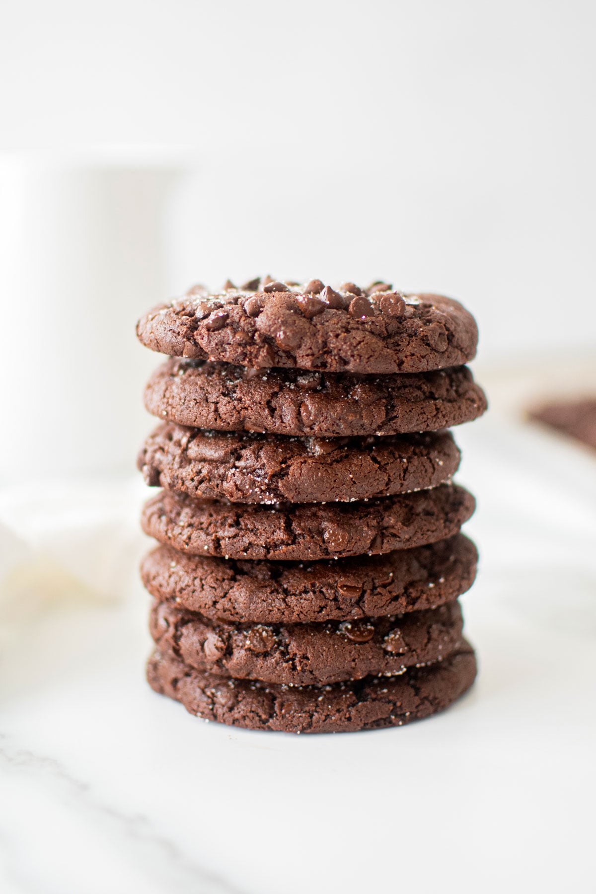 stack of chewy chocolate espresso cookies on a white marble counter.