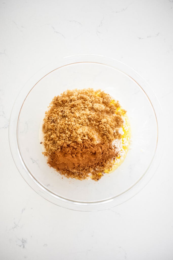 ingredients for streusel topping in a glass bowl on a white marble counter.