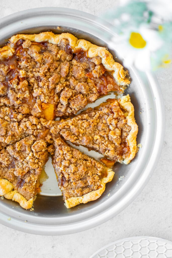 peach crumble pie in a stainless steel pan.