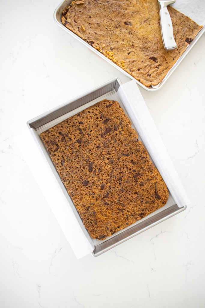 sourdough chocolate chip cookie placed in a 9x13-inch baking pan on a white marble counter.
