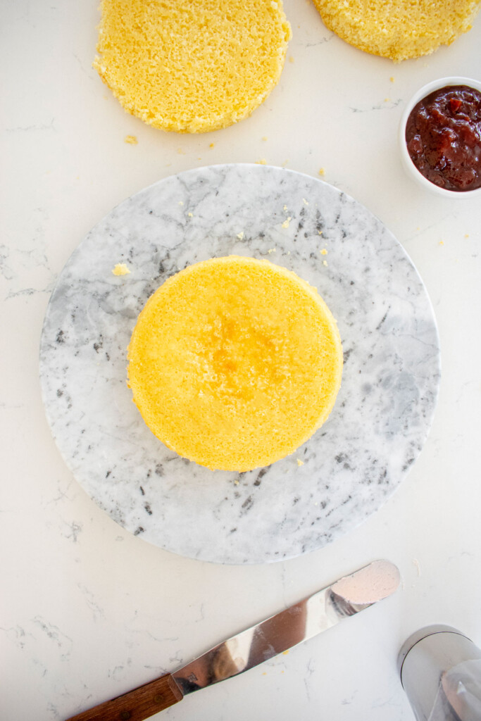 marble cake spinner with a vanilla cake placed on top.