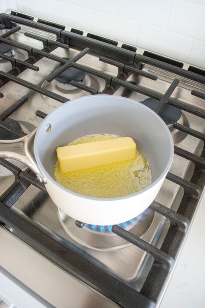 butter being melted in a small saucepan over the stovetop.