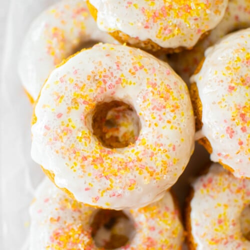 carrot cake donuts with apple cider glaze on a cooling rack.