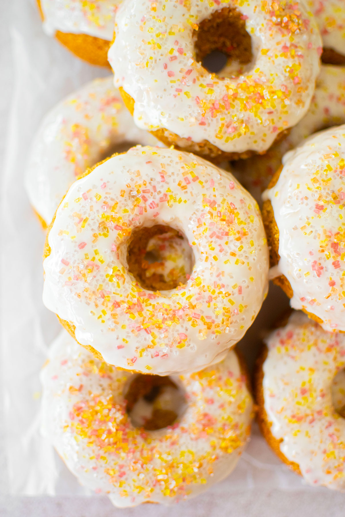 carrot cake donuts with apple cider glaze on a cooling rack.