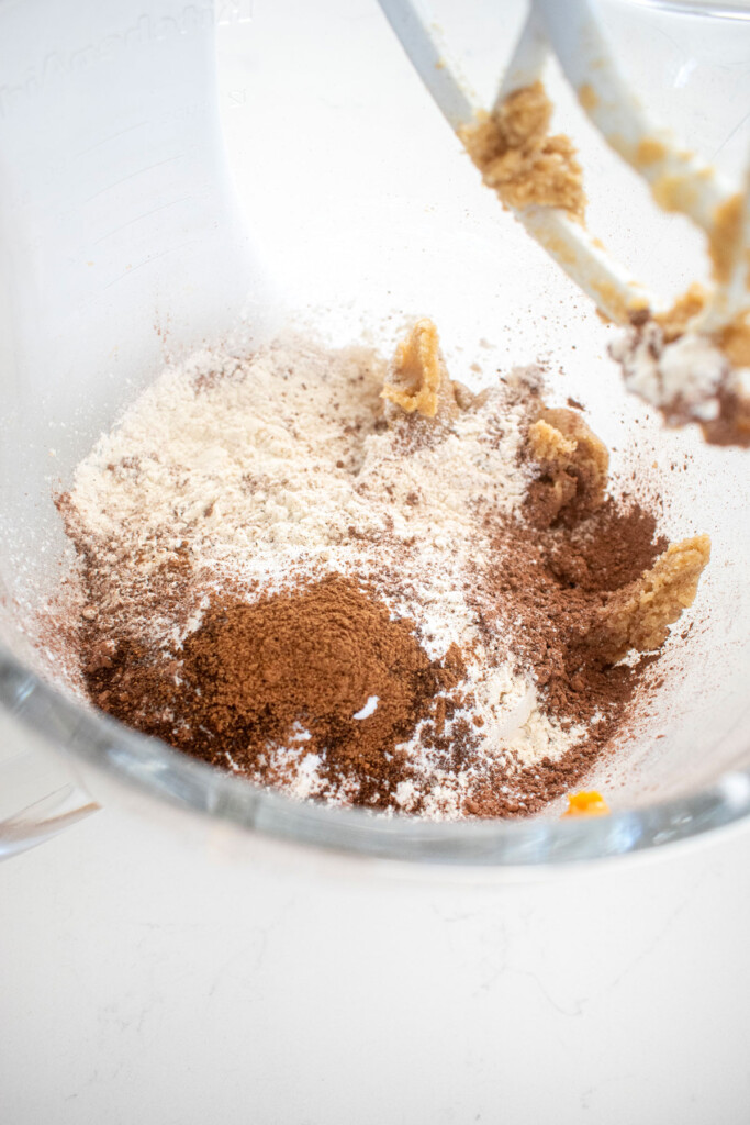 ingredients for double chocolate pumpkin cookies in a glass mixing bowl.