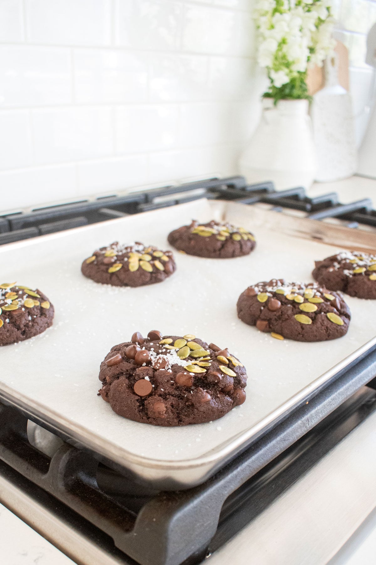 double chocolate pumpkin cookies cooling on a baking sheet on top of the oven.