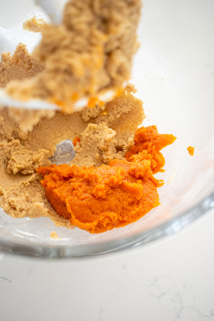creamed butter and sugar with pumpkin in a glass mixing bowl.