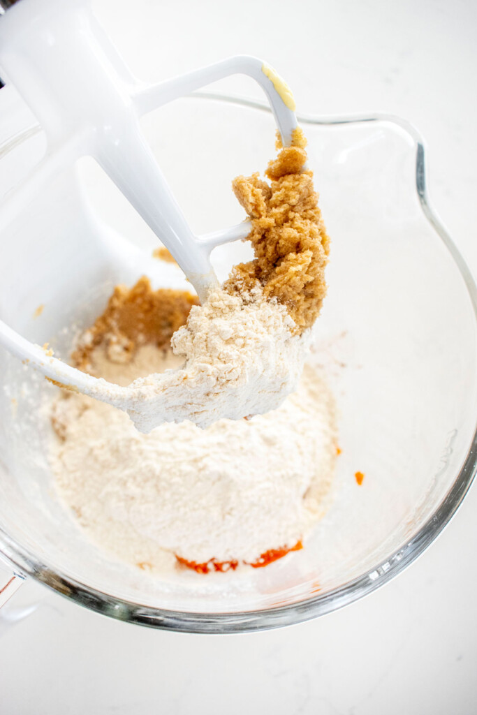 ingredients for pumpkin chocolate chip cookie cake in a glass mixing bowl.