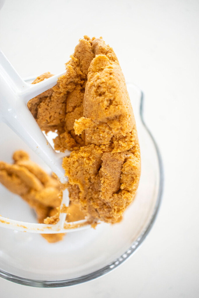 pumpkin cookie dough in a glass mixing bowl.