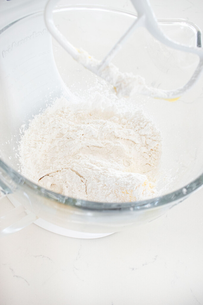 ingredients for buttercream frosting in a glass mixing bowl.
