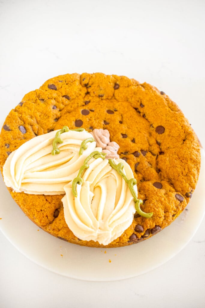 pumpkin chocolate chip cookie cake with white frosting pumpkins.