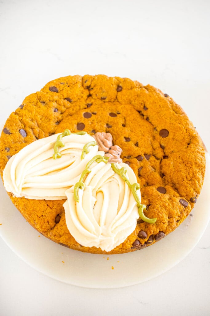 pumpkin chocolate chip cookie cake with white frosting pumpkins.