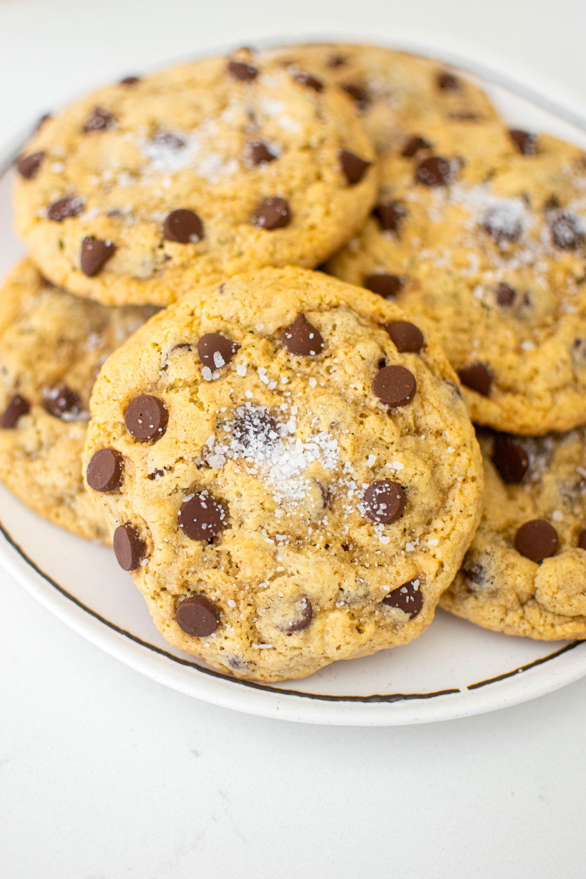 maple brown sugar cookies on a white plate on a white marble counter.