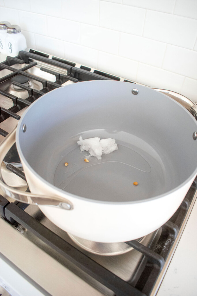 coconut oil and 3 popcorn kernels in a large stock pot on the stovetop. 
