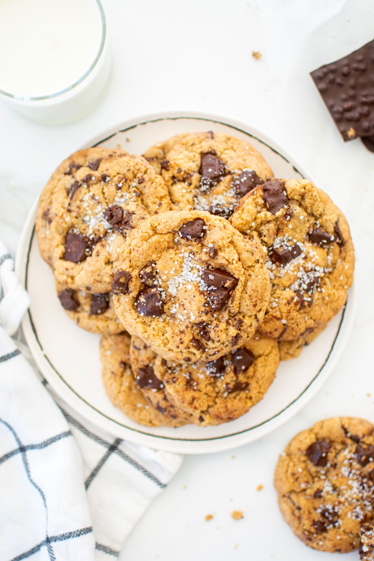 crunch bar cookies on a plate on a white marble counter with a glass of milk.