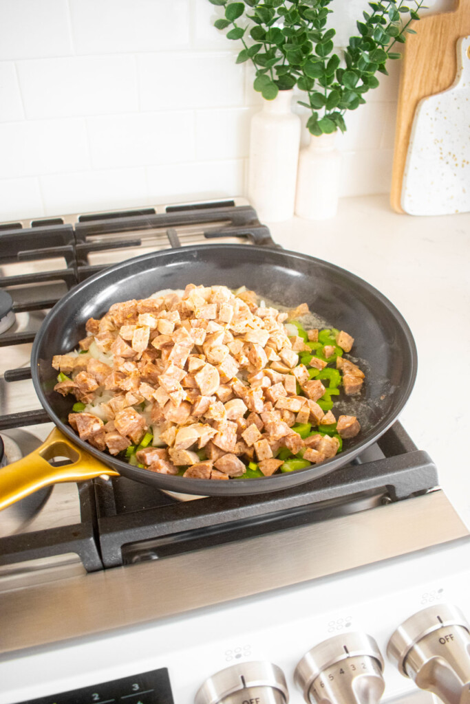 stuffing being cooked in a large skillet on the stovetop.