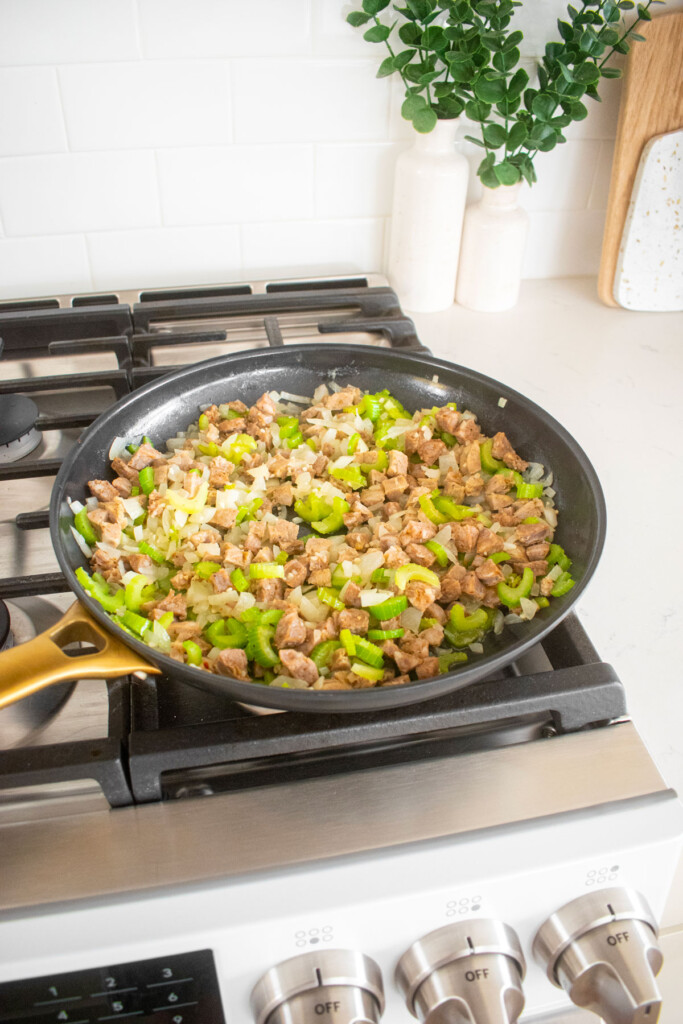 stuffing being cooked in a large skillet on the stovetop.
