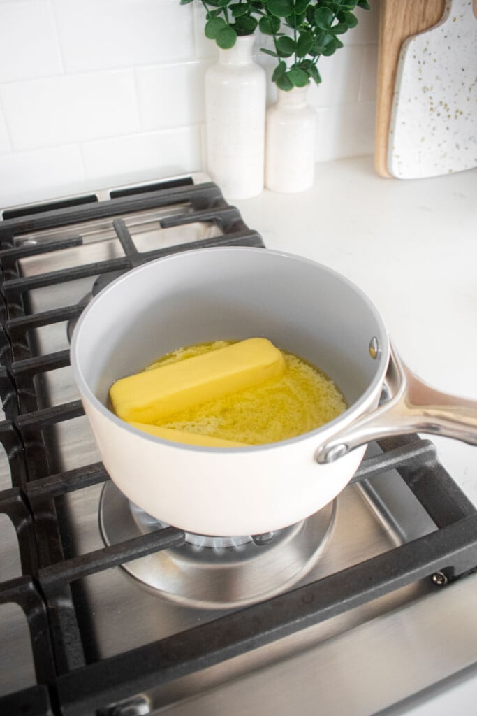 butter melting in a small pot on a stovetop.