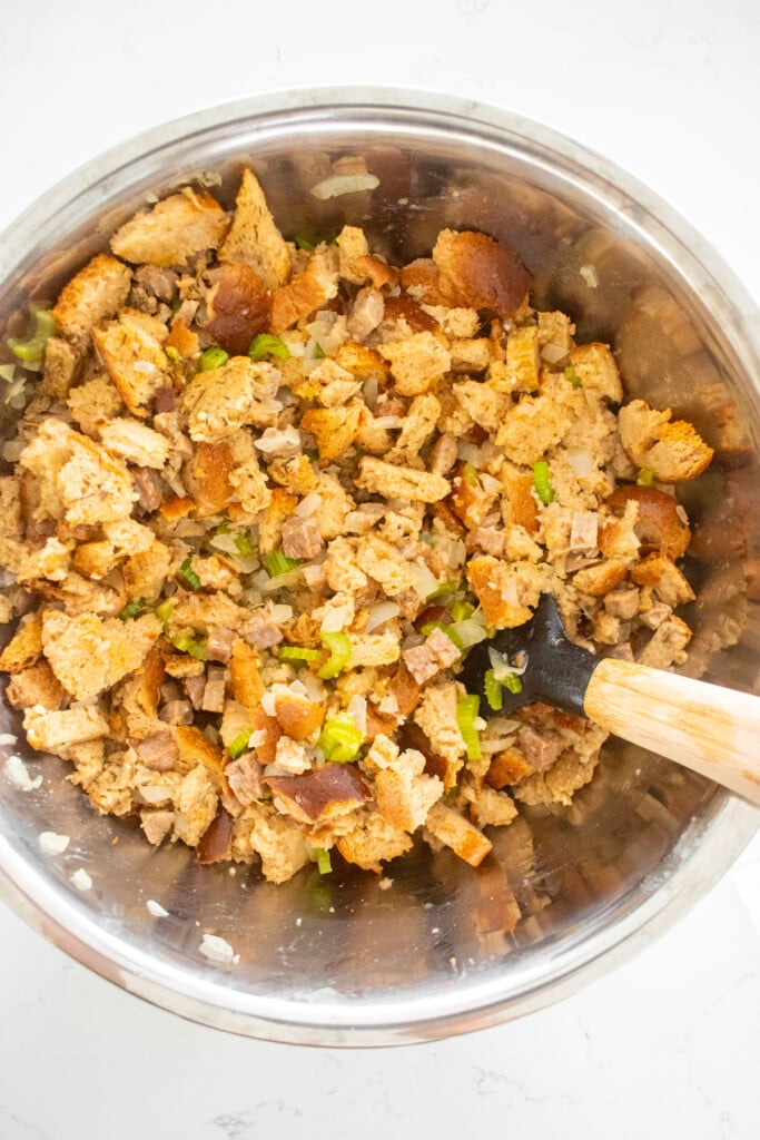 stuffing ingredients in a metal mixing bowl on a white marble counter.