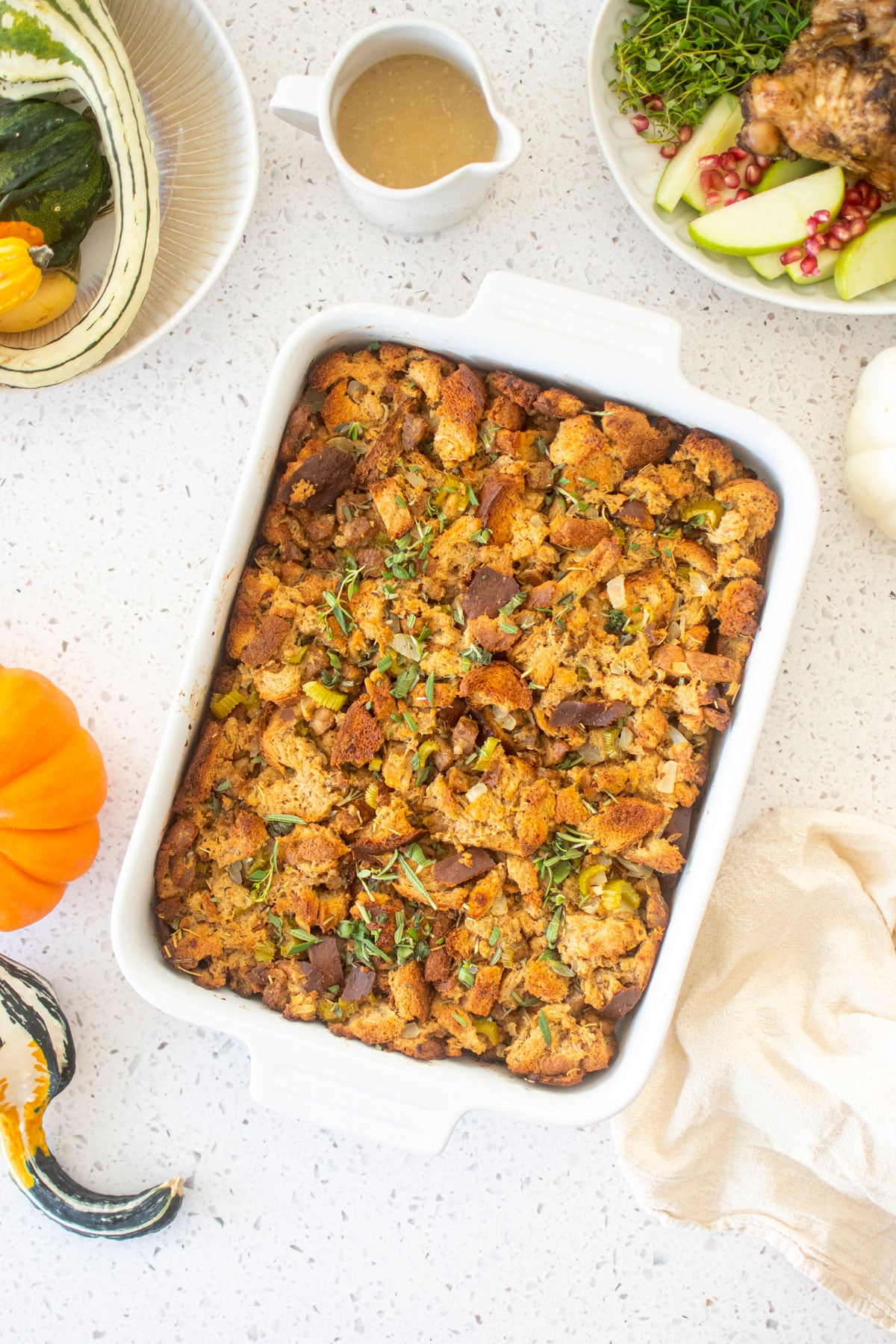 easy stuffing recipe in a white ceramic dish on a white marble table.