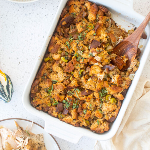 easy stuffing recipe in a white ceramic dish with a wooden serving spoon.