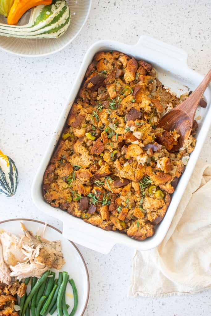 easy stuffing recipe in a white ceramic dish with a wooden serving spoon.
