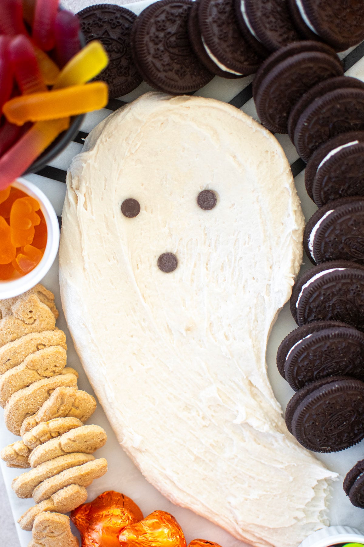 ghost frosting on a halloween dessert board.