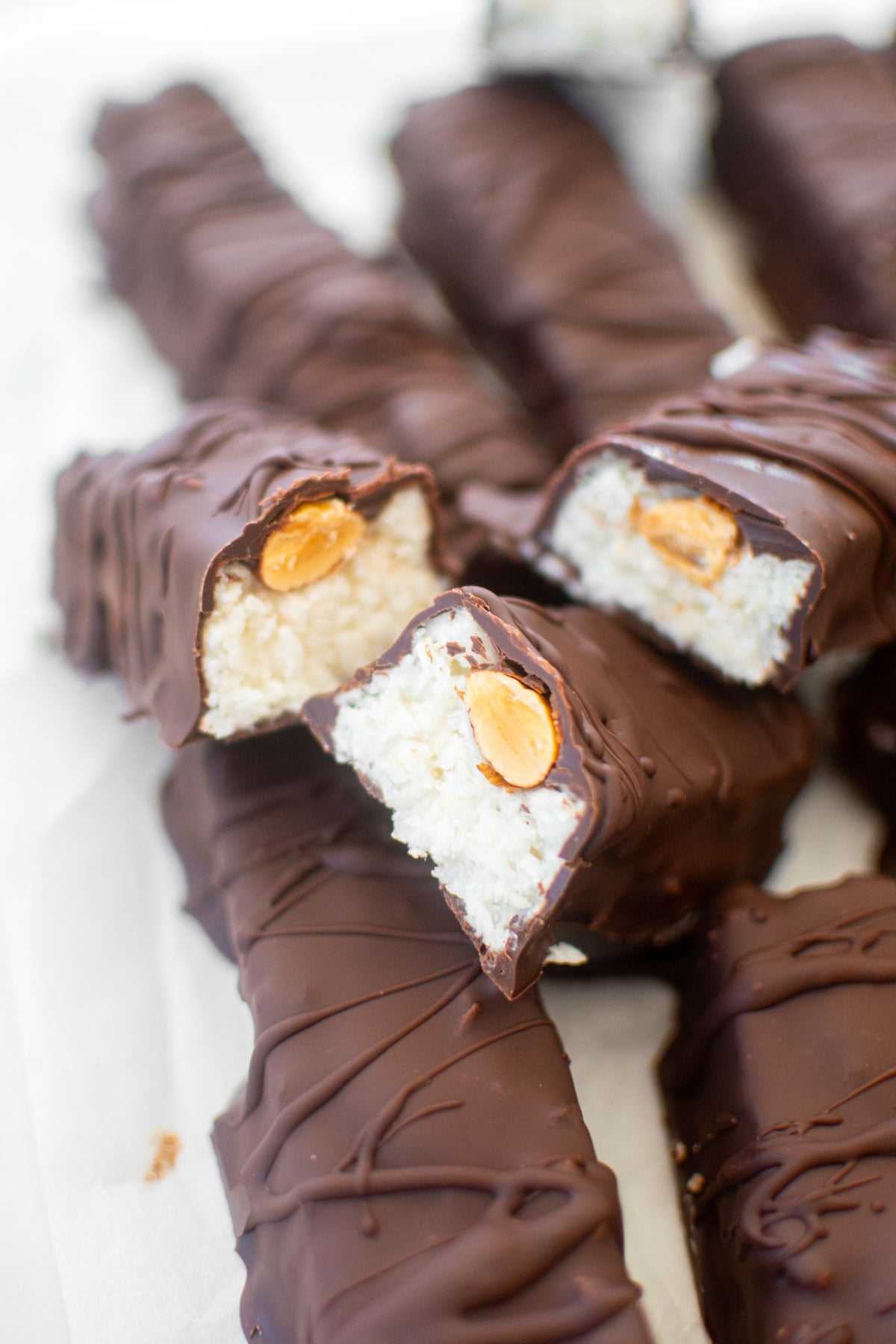healthy almond joy bar cut in half sitting on top of another almond joy bar.