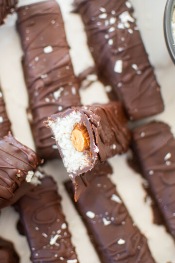 healthy almond joy bar cut in half sitting on top of another almond joy bar.