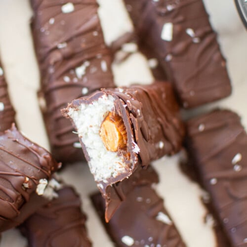 healthy almond joy bar cut in half sitting on top of another almond joy bar.