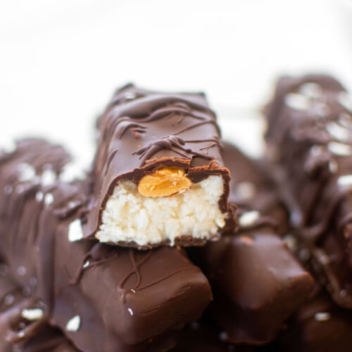healthy almond joy bar cut in half sitting on top of another almond joy bar.