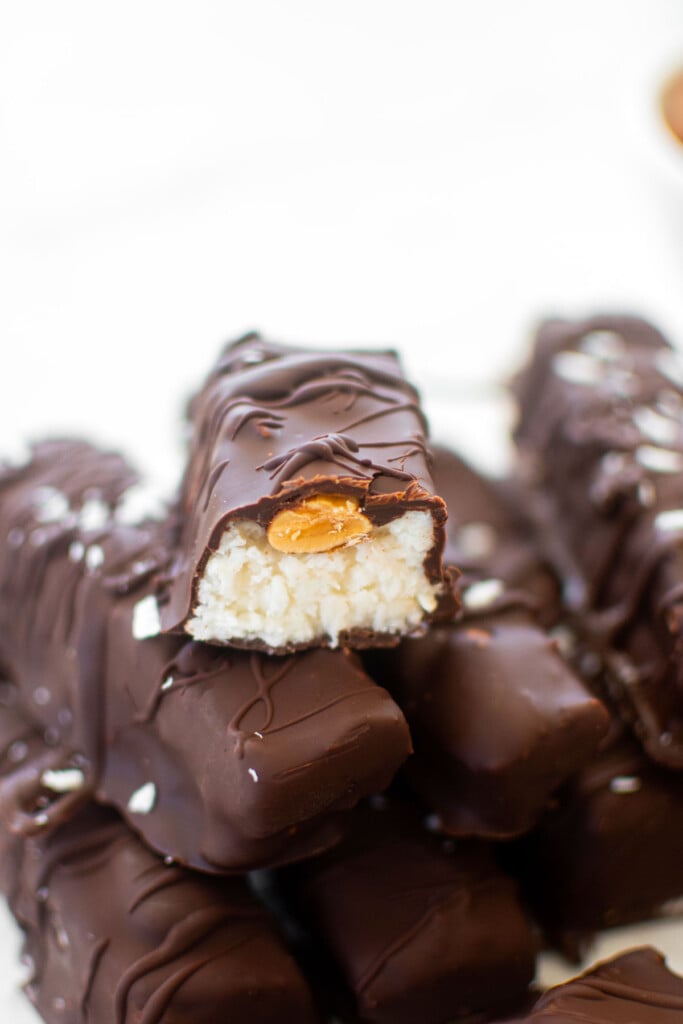 healthy almond joy bar cut in half sitting on top of another almond joy bar.