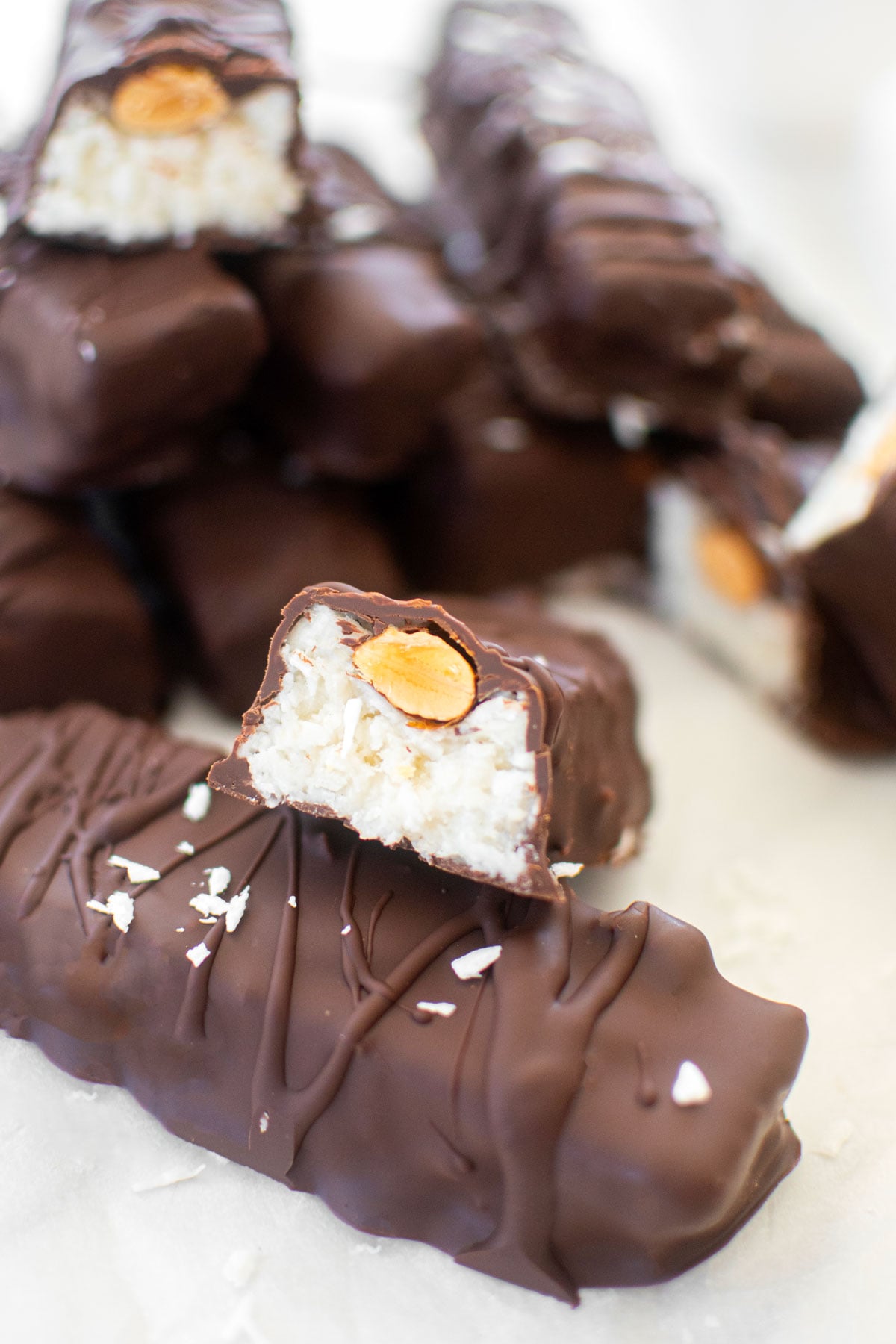 healthy almond joy bar cut in half sitting on top of another almond joy bar.