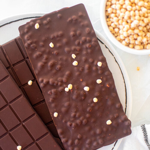 homemade crunch bars on a plate on a white marble counter.