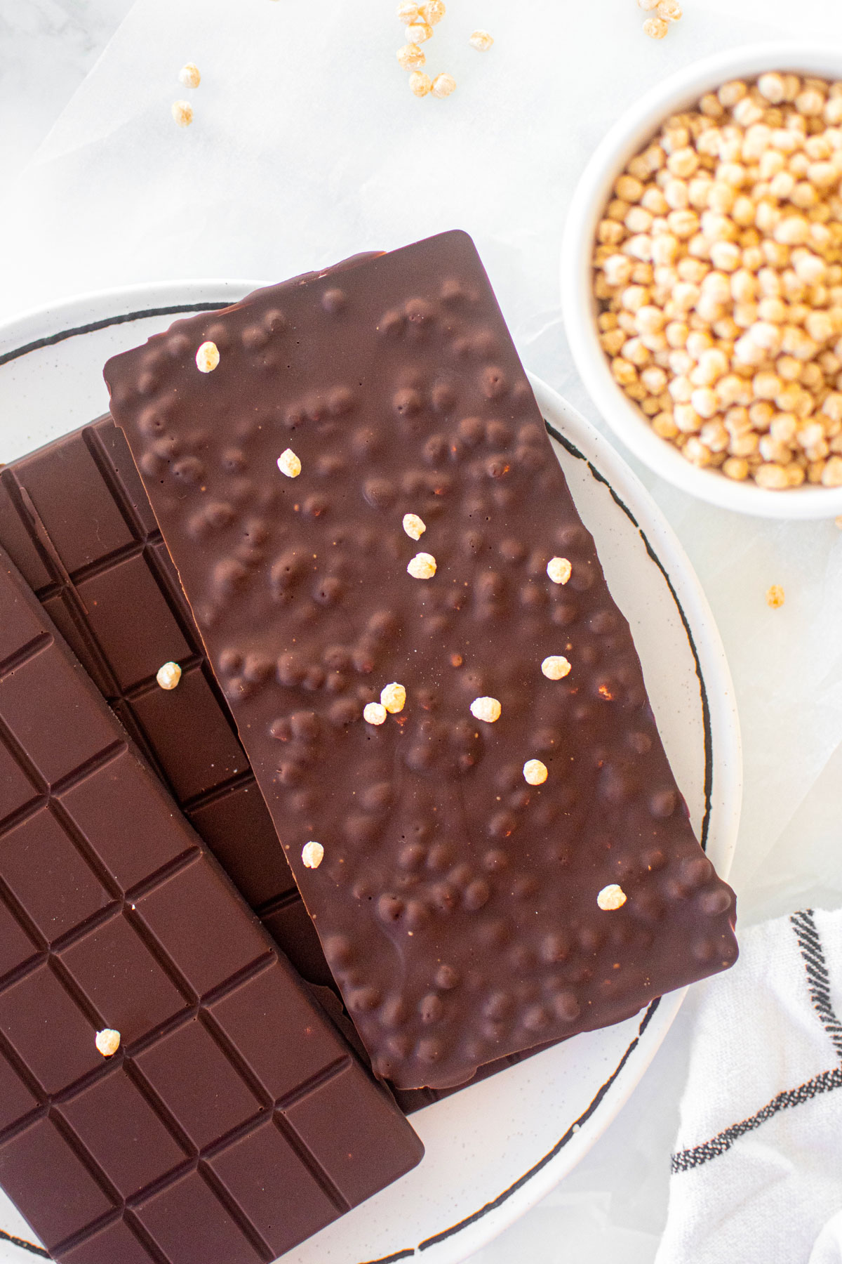 homemade crunch bars on a plate on a white marble counter.