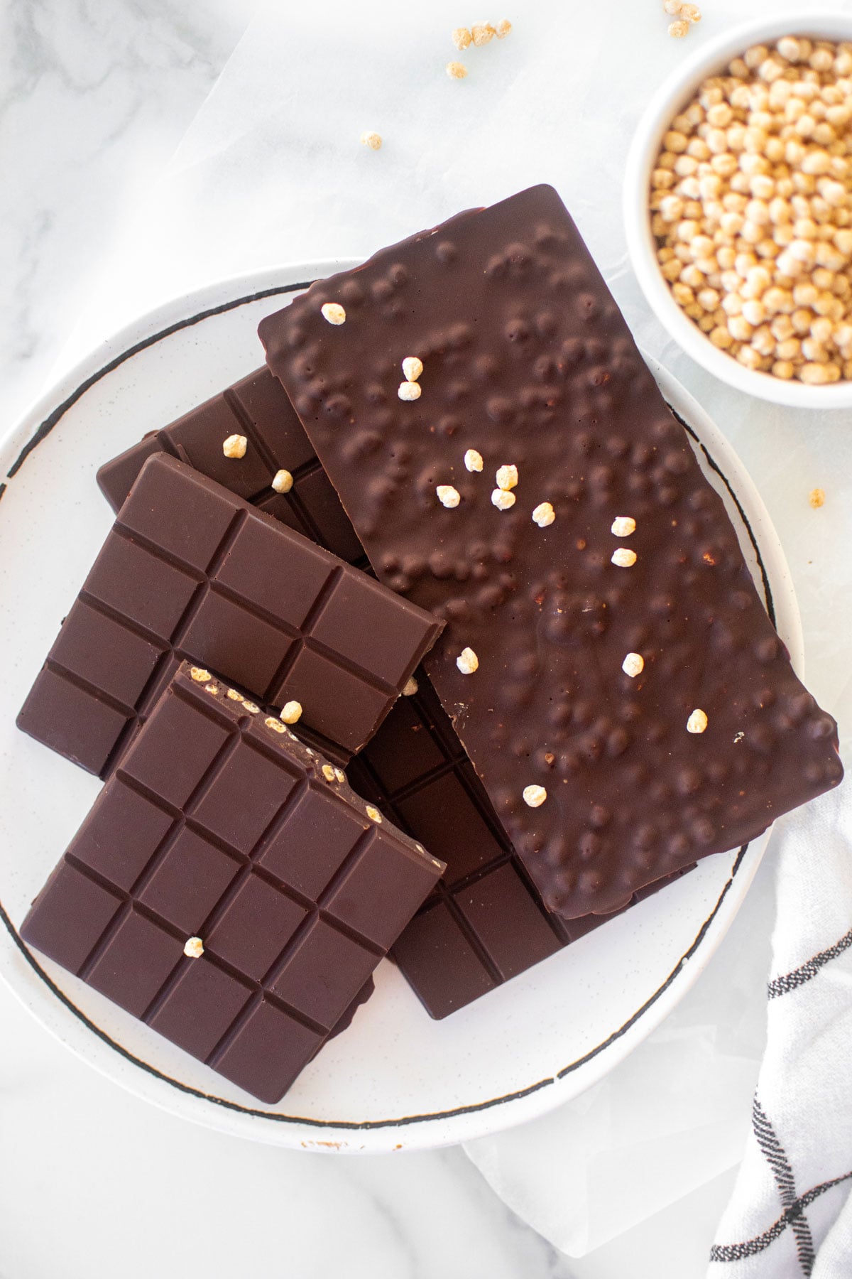 homemade crunch bars on a plate on a white marble counter.