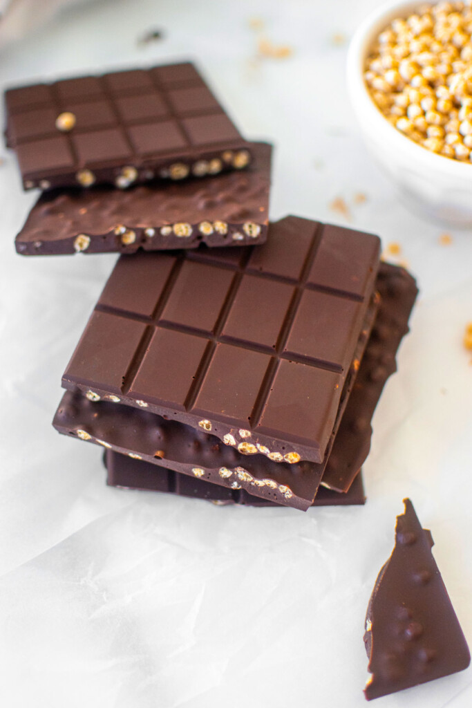 homemade crunch bars on a white marble counter broke in half.