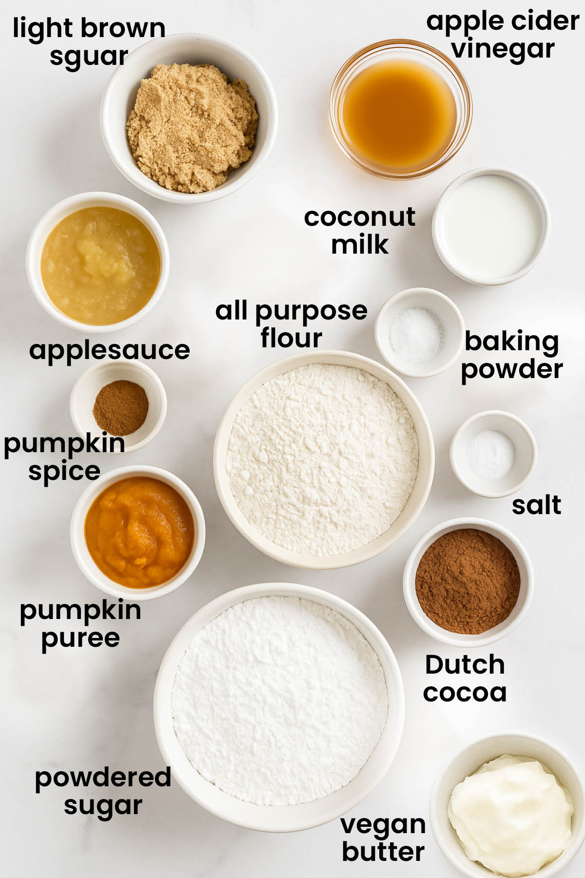 individual ingredients for vegan pumpkin cupcakes with chocolate frosting laid out against a white background.