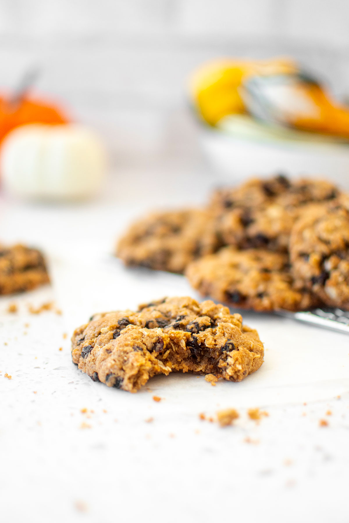 vegan spiced oatmeal raisin cookie with a bite taken out on a white marble counter.