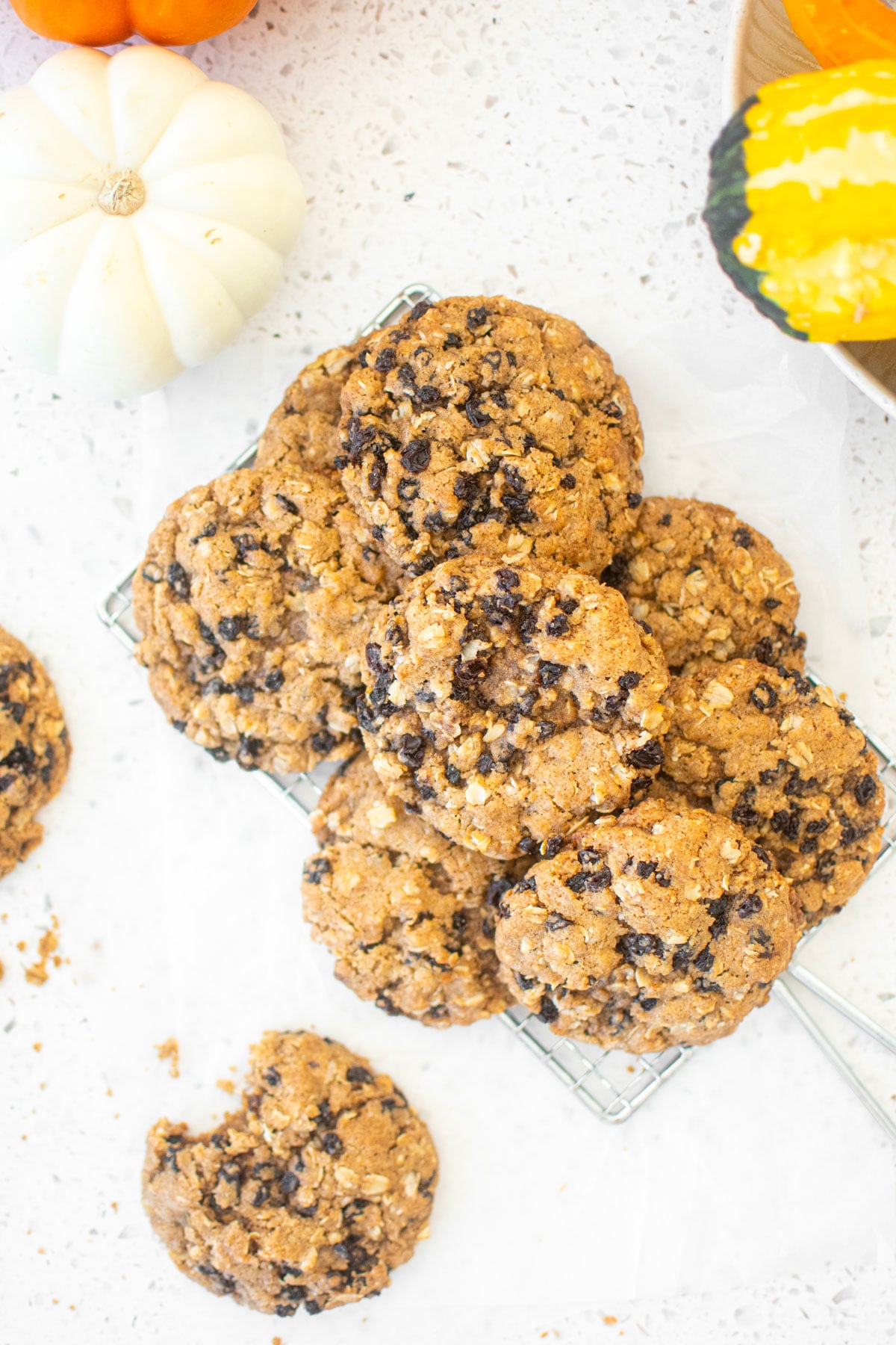 vegan spiced oatmeal raisin cookies on a cooling rack on a white marble counter.